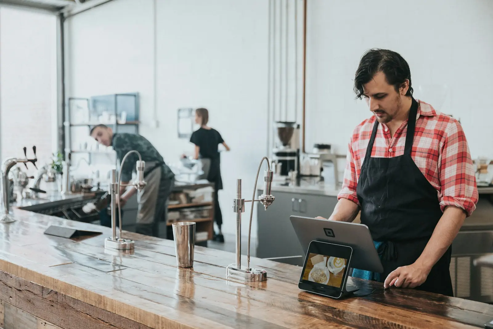 เจ้าของร้านกาแฟกำลังใช้แท็บเล็ตที่เคาน์เตอร์ร้าน