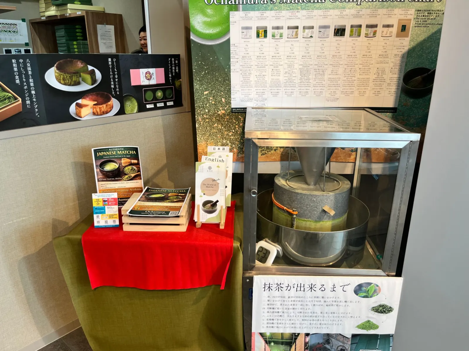 โม่หินบดมัทฉะในตู้กระจก ข้างตารางเปรียบเทียบมัทฉะของ Ochamura และแผ่นพับภาษาอังกฤษ
